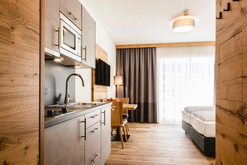 瓦兹Kopeindlgut Apartments的一个带水槽的厨房和一张位于客房内的床
