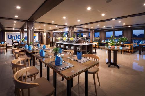 下龙湾UniCharm Cruise的一间在房间内配有桌椅的餐厅