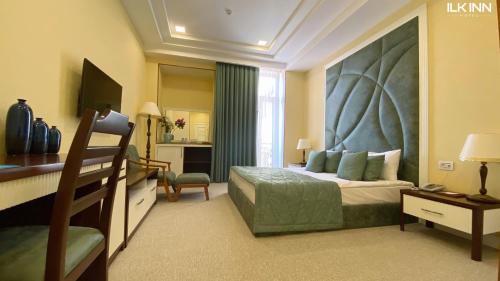 库萨雷ILK INN HOTEL的一间卧室配有一张带大床头板的床