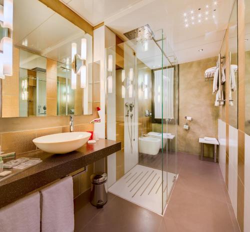 米兰c-hotels Rubens的一间带水槽和玻璃淋浴的浴室