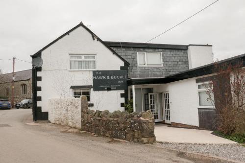 LlannefyddThe Hawk & Buckle Inn的带有读出休息时间的标志的建筑物