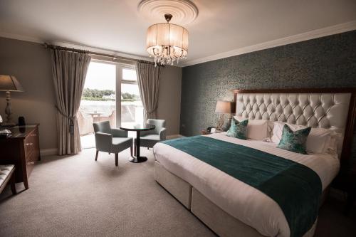 阿赛克兰拉尔德酒店的一间卧室配有一张大床和一张桌子及椅子