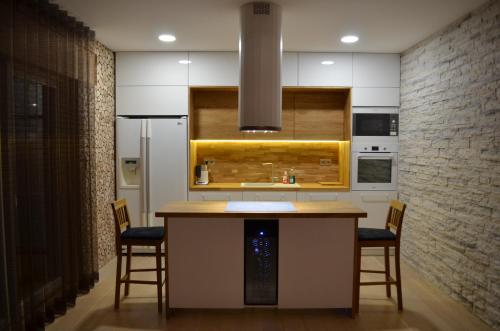 库雷萨雷Ravila Puhkemaja的厨房配有带椅子的柜台和冰箱。