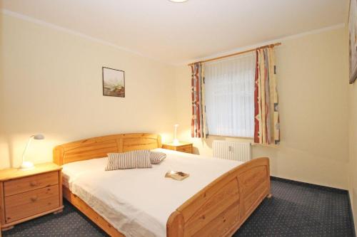 奥斯赛拜-屈隆斯博恩Haus-Ostseewelle-Wohnung-5-411的一间卧室设有一张木床和一个窗户。