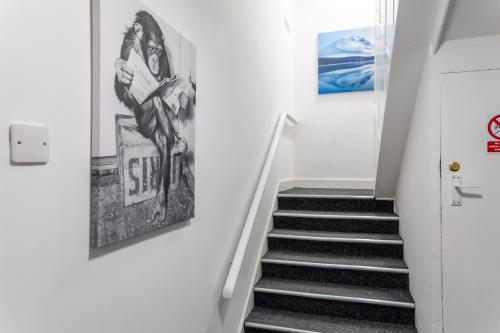 达灵顿Darlington Town Centre Apartments free parking and Wi-Fi的走廊上设有楼梯和墙上的海报