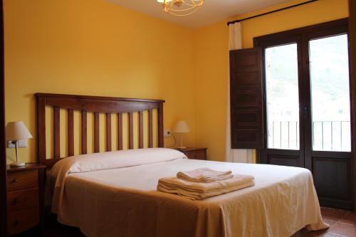 Noguera de AlbarracinApartamentos NOGUERA de ALBARRACÍN的一间卧室配有带毛巾的床