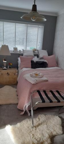 布莱克伍德The lodge的一间卧室配有一张带粉色毯子的大床