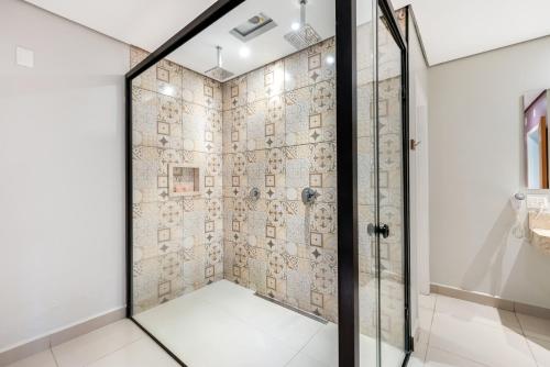 索罗卡巴Plaza Motel的浴室里设有玻璃门淋浴