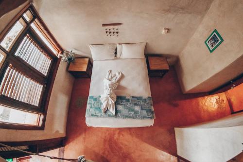 Los Guineos Perdidos阿尔托斯卡诺弘多酒店的客房内的一张床上景色