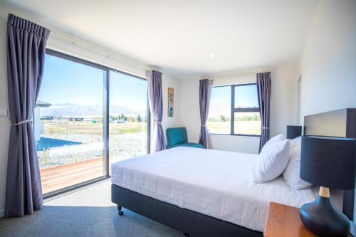 特卡波湖Neptune - Lake Tekapo的一间卧室设有一张大床和一个大窗户