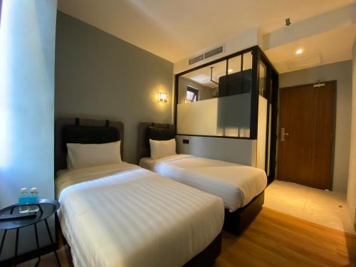 哥打京那巴鲁The Seraya Hotel的酒店客房,设有两张床和镜子