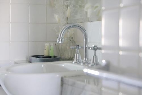 墨尔本Hotel Collins的白色的浴室设有水槽和镜子