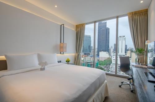 曼谷Amara Bangkok Hotel的一间酒店客房,设有一张大床和一个大窗户