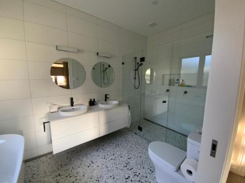 卢拉La Casétta的白色的浴室设有2个盥洗盆和淋浴。