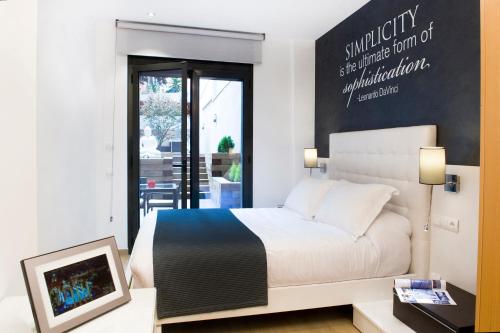 巴塞罗那Home to Home Barcelona的一间卧室配有一张床和一张书桌及电视