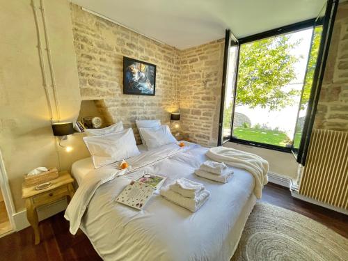 博讷MonCoeur, maison et jardin à 700 m des Hospices de Beaune的卧室配有带毛巾的大型白色床