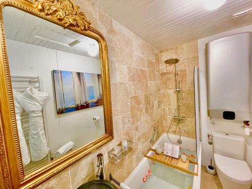 博讷MonCoeur, maison et jardin à 700 m des Hospices de Beaune的浴室设有镜子、水槽和浴缸