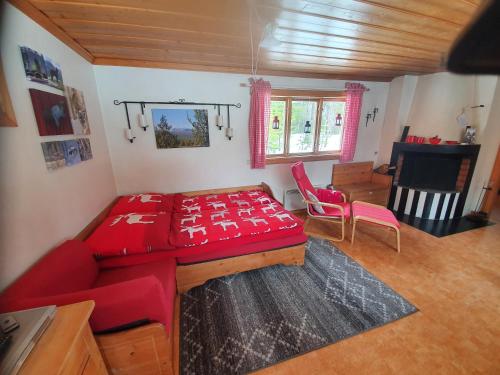 Nedre Norra ÖrnäsHaus am Lachsfluss的一间设有红色床和桌椅的房间