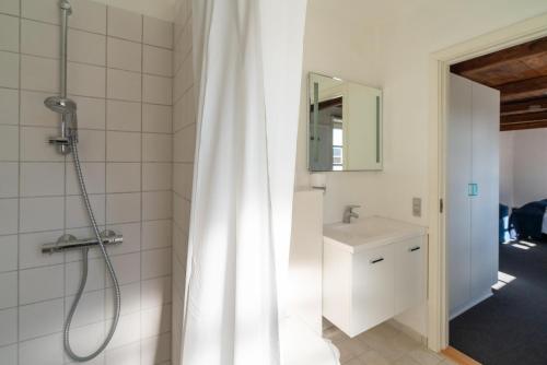 克利特默勒Klitmøller Badehotel的浴室配有淋浴帘和盥洗盆。