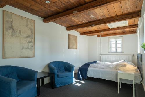 克利特默勒Klitmøller Badehotel的一间卧室配有2把蓝色椅子和1张床