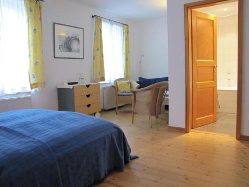 赖因斯贝格Der Seehof Rheinsberg的一间卧室配有一张床、一张桌子和一把椅子