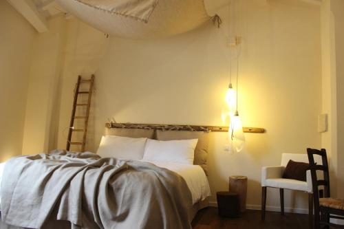 格拉维纳普利亚Fondo Vito的一间卧室配有一张床、梯子和椅子