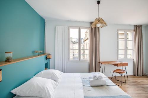 圣马洛Le Cap Cézembre - Intra-Muros Saint-Malo的蓝色的卧室配有白色的床和书桌