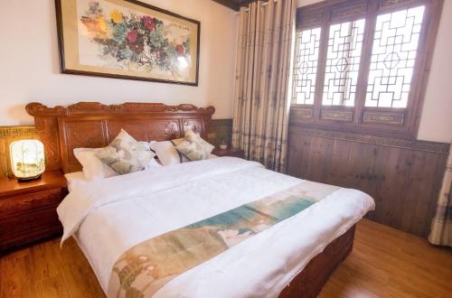 黟县杏竹斋客栈的一间卧室配有一张大床和木制床头板