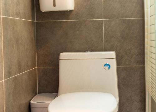 黟县杏竹斋客栈的浴室设有白色卫生间,位于瓷砖墙壁上
