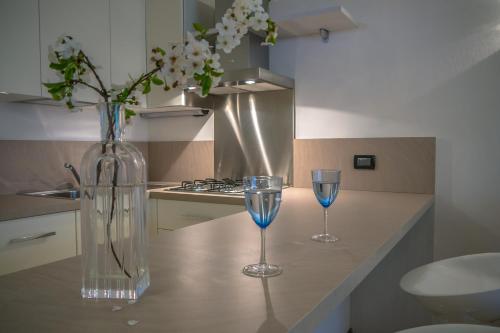 马内尔巴奥斯酒店的厨房柜台上放有两杯酒杯和花瓶