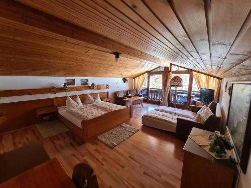 柯尼希斯湖畔舍瑙Alpenpension Bergidyll的大房间设有两张床和一张沙发