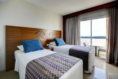 库亚巴Advanced Hotel & Flats Cuiabá的酒店客房设有两张床和窗户。