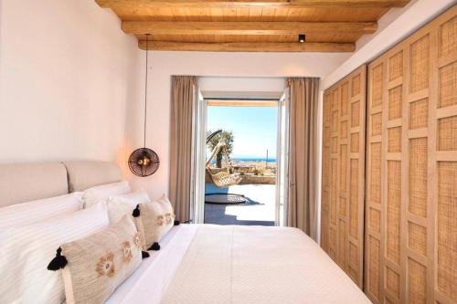卡拉法蒂斯Blue Orchid Villa Mykonos的一间卧室配有一张床,享有海景