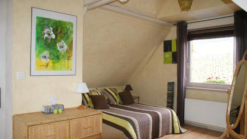 Sigolsheim沃格尔花园商会酒店的一间卧室设有一张床和一个窗口