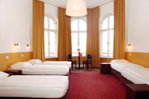 柏林柏林经典格兰德旅舍的带三张床和桌椅的房间