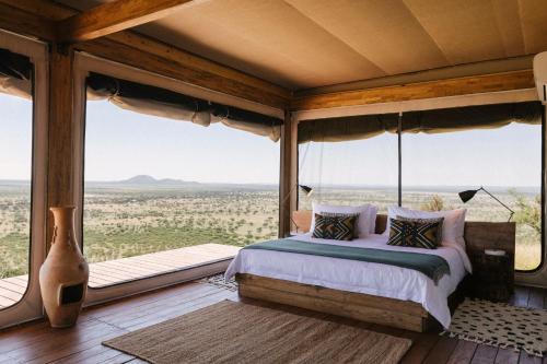 温特和克Our Habitas Namibia的一间卧室设有一张床和一个大窗户