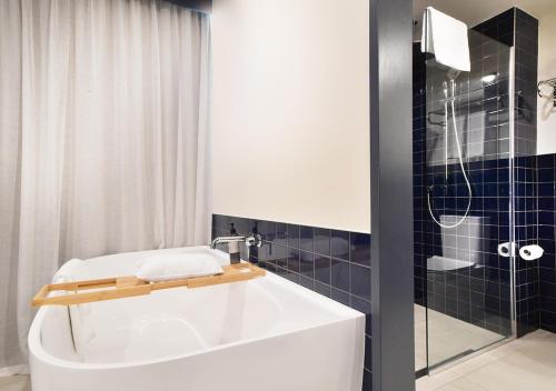 奥克兰Sudima Auckland City的浴室配有白色浴缸和淋浴。