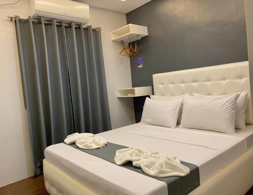 长滩岛Viajeros Hostel Boracay的一间卧室配有一张床,上面有两条毛巾