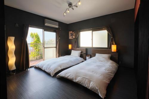 明石市Awaji Aquamarine Resort #1 - Self Check-In Only的一间卧室设有两张床和窗户。