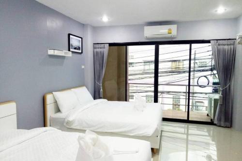 合艾Khoksametchun Hostel Plus的一间卧室设有两张床和大窗户