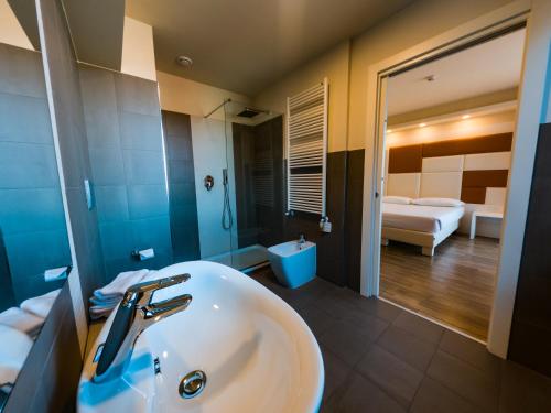 梅多拉戈Hotel Sirio - Sure Hotel Collection by Best Western的一间带水槽的浴室和一间卧室