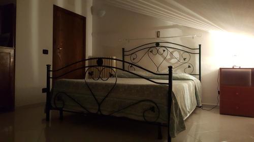 Santa LuciaB & B La Mansarda的一间卧室配有一张带锻铁框架的床