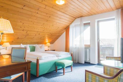 朗根阿根Pension Auszeit的酒店客房设有床、桌子和窗户。