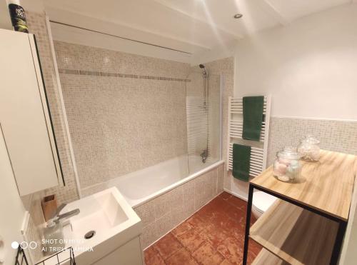 卡尔卡松La petite maison dans la bastide的浴室配有白色浴缸、盥洗盆和盥洗盆