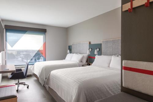 墨尔本avid hotels - Melbourne - Viera, an IHG Hotel的酒店客房设有两张床和窗户。