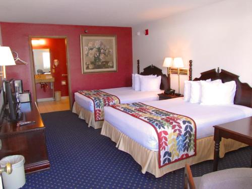 布兰森达顿酒店的红色墙壁的酒店客房内的两张床