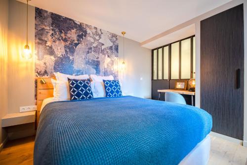 巴黎Residence Les Boulevards的一间卧室配有蓝色的床和一张书桌