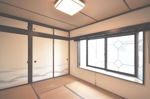 东京Gallery House的一间空房间,设有大窗户和地板