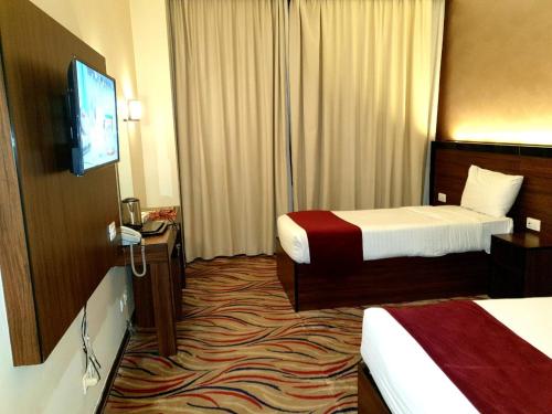 麦地那Hayah Golden Hotel的酒店客房设有两张床和一台平面电视。
