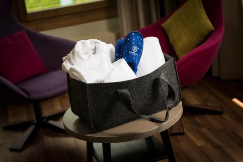 蓬特雷西纳阿勒格拉酒店 的一张桌子上一篮毛巾和鞋子